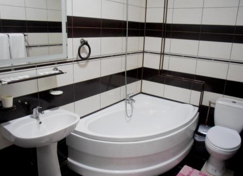 a bathroom with a white toilet and a sink at Pensiunea Crystal II in Valea Lupului