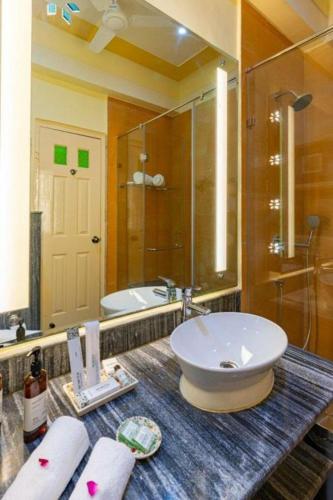 a bathroom with a sink and a large mirror at Anand Bagh Resort & Spa by Ananta in Sālāsar