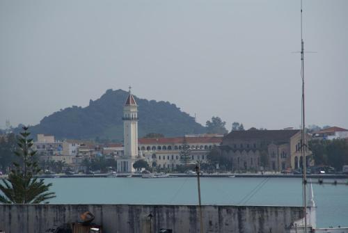 a city with a clock tower next to a body of water at Yria Hotel in Zakynthos Town