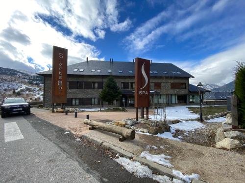 a building with signs on the side of a road at Aparthotel Siente Boí & SPA in Pla de l'Ermita
