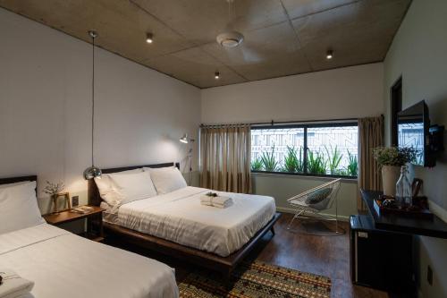 a hotel room with two beds and a window at The Note Dalat in Da Lat