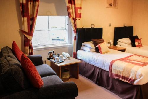 a hotel room with two beds and a couch at Station Hotel And Restaurant in Melrose
