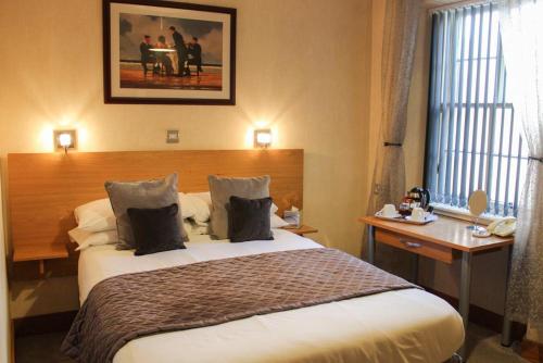 a hotel room with a large bed and a desk at Station Hotel And Restaurant in Melrose