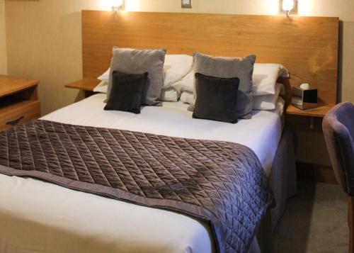 a hotel room with a large bed with two pillows at Station Hotel And Restaurant in Melrose