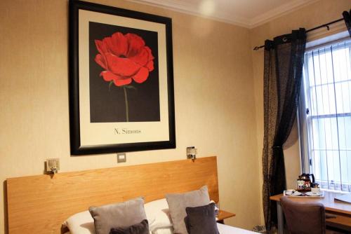 a bedroom with a bed with a red flower on the wall at Station Hotel And Restaurant in Melrose