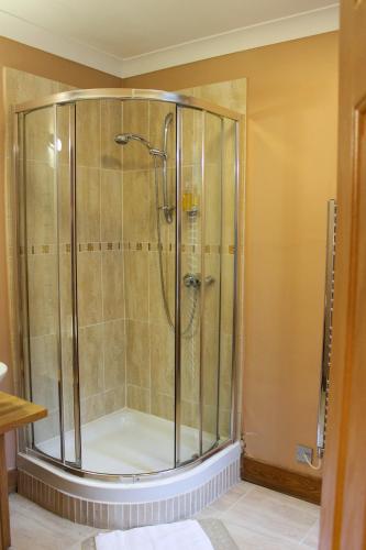 a shower with a glass door in a bathroom at Station Hotel And Restaurant in Melrose