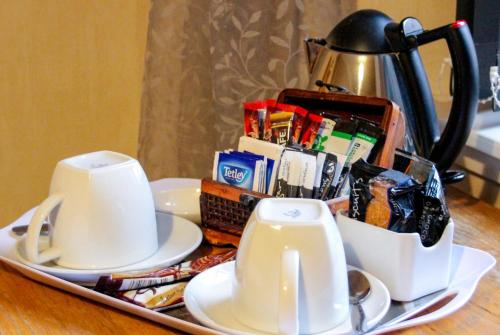 a tray with a tea pot and cups on a table at Station Hotel And Restaurant in Melrose