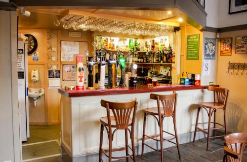 un bar con taburetes de madera delante en Station Hotel And Restaurant en Melrose