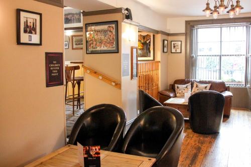 a living room with leather chairs and a table at Station Hotel And Restaurant in Melrose