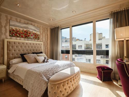 a bedroom with a large bed with a large window at MyCityHome - Luxurious apartment on Calle O'Donnell in Madrid