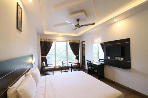 a hotel room with a bed and a television at Jays Inn in Munnar