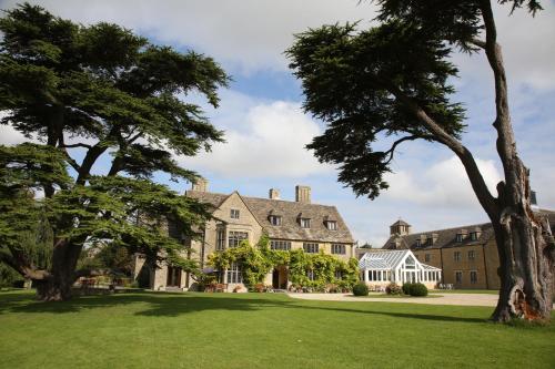 an exterior view of a large house with trees at Stanton House Hotel in Swindon