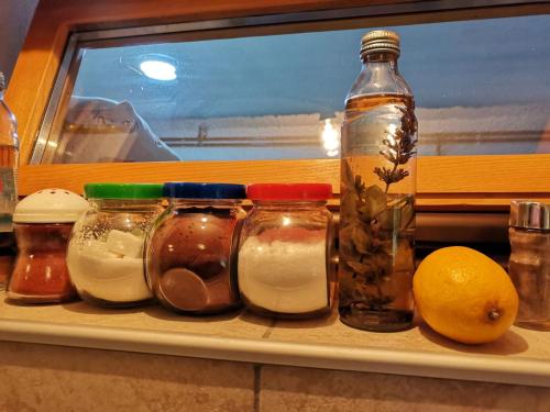 a shelf with jars and an orange and a window at Vikendica Ole Apartman 2. in Pale