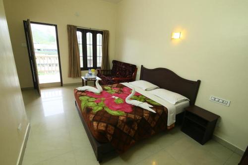 a bedroom with a bed and a chair at Jays Inn in Munnar