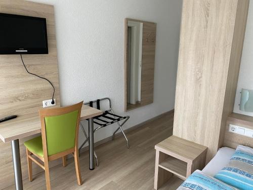 バート・メルゲントハイムにあるGasthof Linde-Classicoのデスク、テーブル、椅子が備わる小さな客室です。