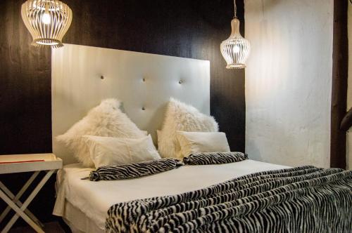 a bedroom with a bed with pillows and two lights at Shangrila-innibos Country Lodge in Hartbeespoort
