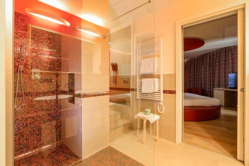 a bathroom with a walk in shower and a glass door at Hotel Glamour in Bassano del Grappa