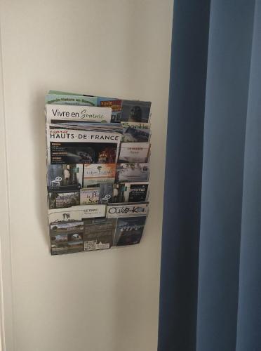 a bunch of magazines hanging on a wall at Gite de la Baie des anges in Saint-Valery-sur-Somme