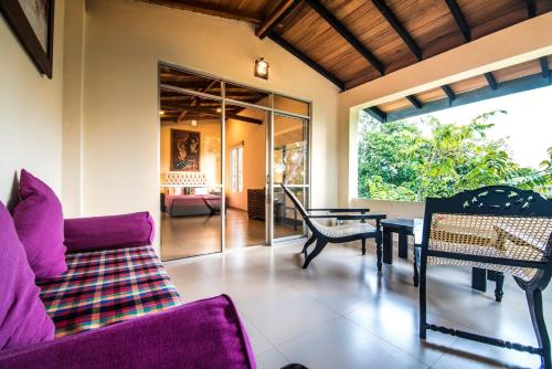 a living room with a purple couch and a table at Ella Planters Bungalow in Ella