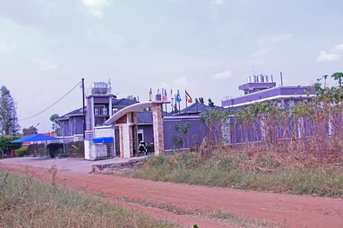 a building with a fence next to a dirt road at Bethel Resort & Hotels in Gulu