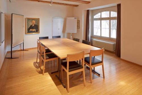 a dining room with a wooden table and chairs at See & Park Hotel Feldbach in Steckborn