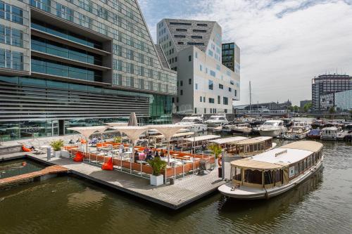 a marina with several boats docked in a city at Room Mate Aitana in Amsterdam