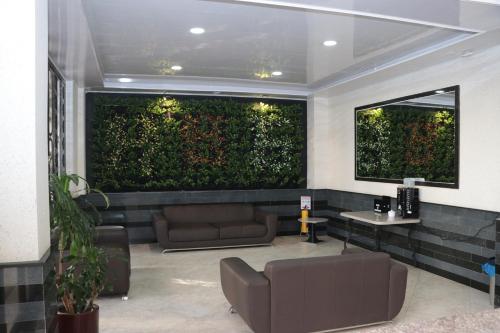 a living room with a large green wall at Hotel Castellana Group in Bogotá