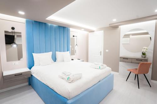 a blue and white bedroom with a bed and a chair at SHIMresidence LUXURY in Rădăuţi