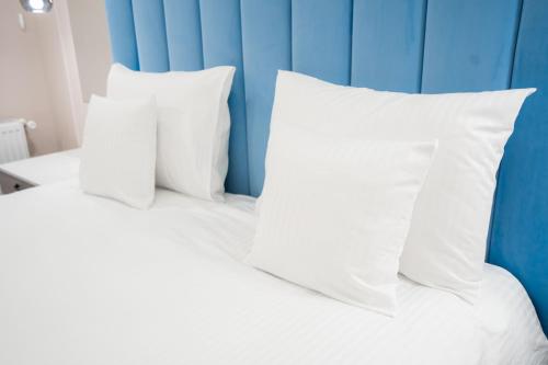 two white pillows on a bed with a blue wall at SHIMresidence LUXURY in Rădăuţi