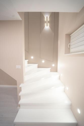 a white staircase in a room with a cross on the wall at SHIMresidence LUXURY in Rădăuţi