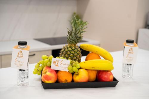 a tray of fruit on a counter with two bottles of water at SHIMresidence LUXURY in Rădăuţi