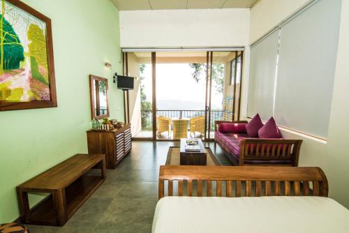 a living room with a bed and a couch at Ella Planters Bungalow in Ella