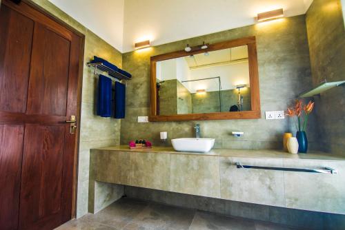 a bathroom with a sink and a mirror at Ella Planters Bungalow in Ella