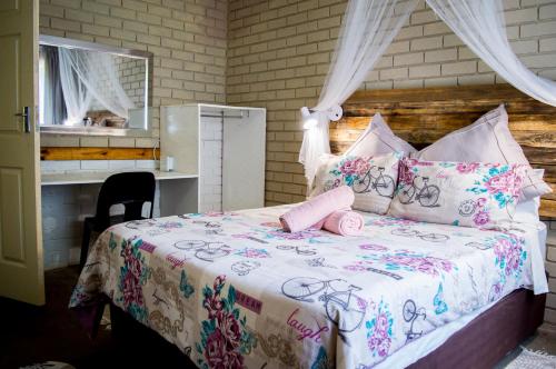 a bedroom with a bed with a dresser and a mirror at Shangrila-innibos Country Lodge in Hartbeespoort