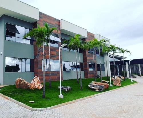 a building with palm trees in front of it at Hotel D'Leon in Gurupi