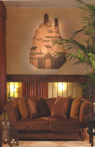 a couch in a living room with a painting on the wall at Hotel Del Borgo in Bologna