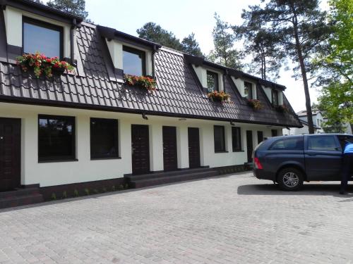 a blue car parked in front of a building at Camping Motel WOK in Warsaw