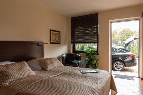 a bedroom with a bed and a car parked in a driveway at Camping Motel WOK in Warsaw