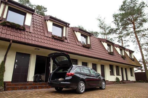a small car parked in front of a house at Camping Motel WOK in Warsaw