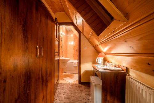 a bathroom with wooden walls and a wooden ceiling at Willa u Zwijaczy in Zakopane
