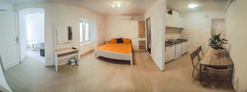 a bedroom with a bed and a kitchen with a table at Studio Apartments & Rooms Lela in Šipanska Luka