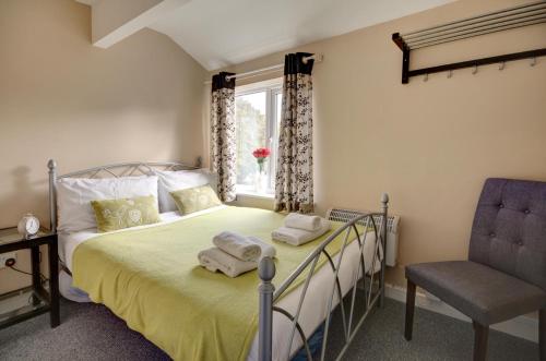 a bedroom with a bed and a chair and a window at Walkers Court By Treetop Property in Cirencester