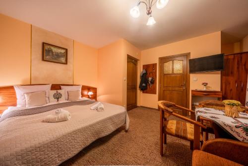 a bedroom with a bed with two towels on it at Willa u Zwijaczy in Zakopane