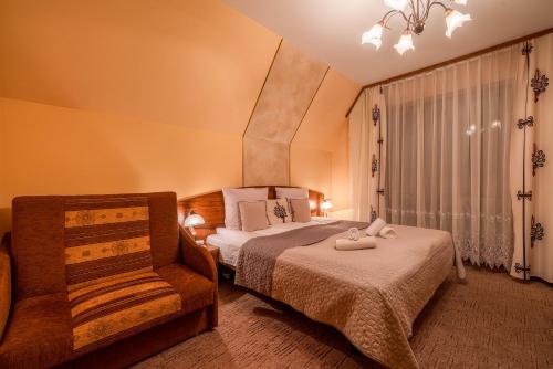 a bedroom with a bed and a chair in it at Willa u Zwijaczy in Zakopane