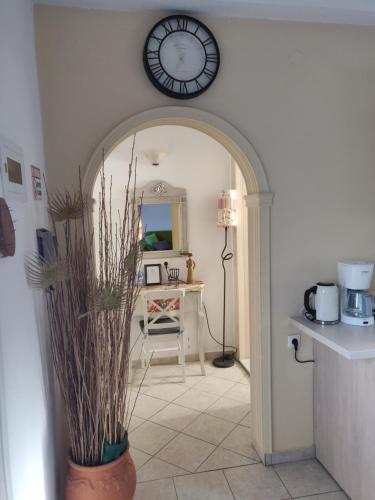 a hallway with a clock on the wall and a table at Efi's apartment in Marathias