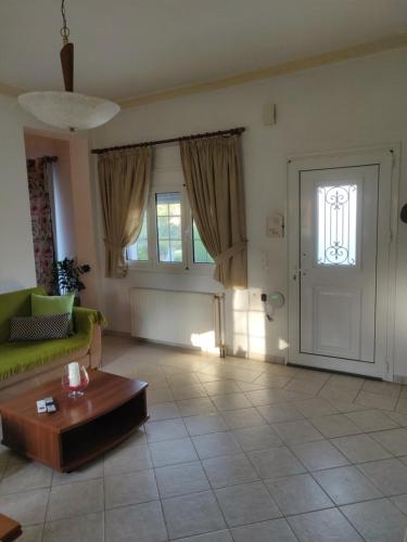 a living room with a couch and a table and a door at Efi's apartment in Marathias