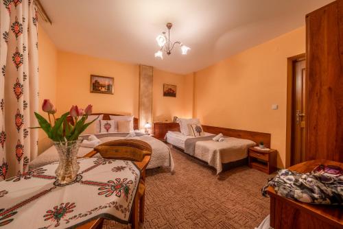 a hotel room with two beds and a table at Willa u Zwijaczy in Zakopane
