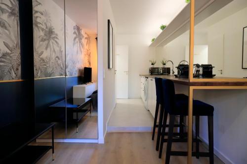 - une cuisine avec un bar et des chaises dans la chambre dans l'établissement Studio l'évasion, parfait pour vous détendre, à Divonne-les-Bains