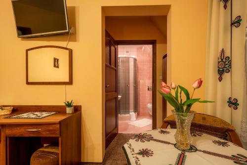 a room with a table with a vase of flowers at Willa u Zwijaczy in Zakopane