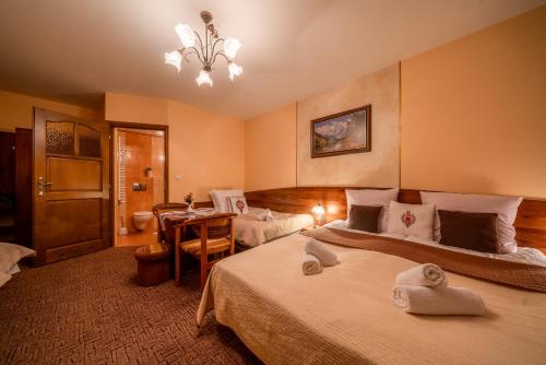 a hotel room with two beds and a table at Willa u Zwijaczy in Zakopane